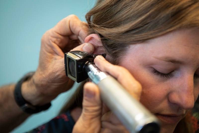 Woman having her ear checked by a doctor
